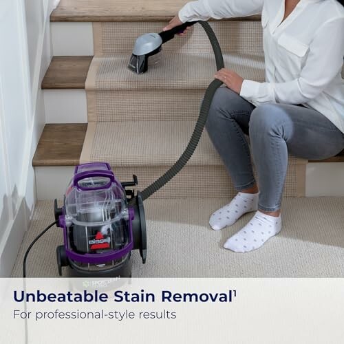 Person using a carpet cleaning machine on stairs.