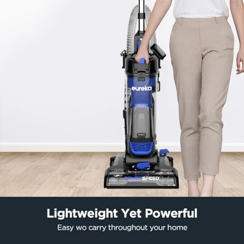 Person holding a lightweight vacuum cleaner on a wooden floor.