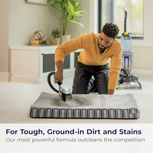 Man using a vacuum cleaner on a carpet in a living room.