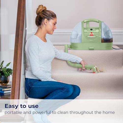 Woman using a portable carpet cleaner on stairs.